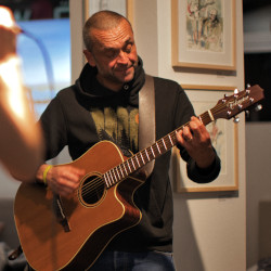 Gerhard Schmitt spielt eine Akustikgitarre